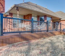 A professionally built wooden deck with safety railing, perfect for outdoor gatherings and relaxing in your backyard. Deckworks custom outdoor deck with railing system for enhanced backyard entertainment.