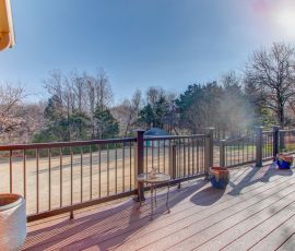 Spacious outdoor deck featuring custom wood decking, stylish railing, and planters, perfect for relaxing and entertaining in a natural setting. Outdoor deck with custom railing, planters, and seating area.