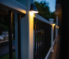 Close-up of a modern deck railing illuminated by built-in LED lights at dusk. LED-lit deck railing for enhanced outdoor living and aesthetic appeal.