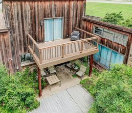 default Custom wooden deck with balcony and outdoor seating area in a residential backyard.