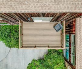 default Elevated view of a modern backyard deck with surrounding greenery and outdoor furniture.