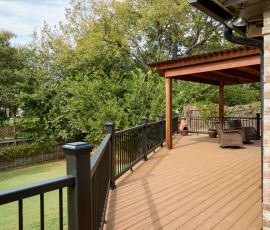 Beautiful backyard deck with wooden flooring, railing, and cozy seating area, perfect for outdoor relaxation and gatherings. Custom wooden deck with railing and outdoor seating in a backyard setting.