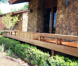 Beautiful custom wood deck with railing, designed for outdoor relaxation and entertainment, built by Deckworks. Custom wooden deck built by Deckworks with natural wood finish and railing, enhancing outdoor living.