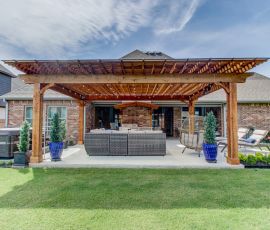 Stylish wooden patio cover with outdoor seating and potted plants, perfect for outdoor entertaining and relaxation. Beautiful wooden patio cover with outdoor furniture in a backyard setting.