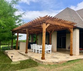Beautiful backyard with custom wooden pergola and stone patio for outdoor gatherings. Pergola for outdoor living and entertaining.